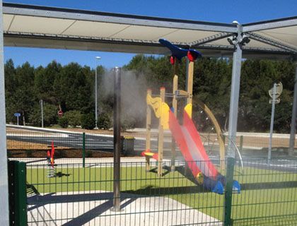 Brumisateurs rafraîchissant une aire de jeux pour enfants dans un espace public